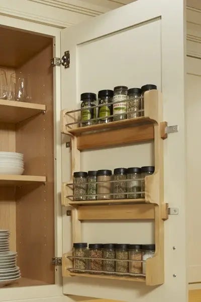 Cabinet door-mounted spice rack on cream shaker cabinets