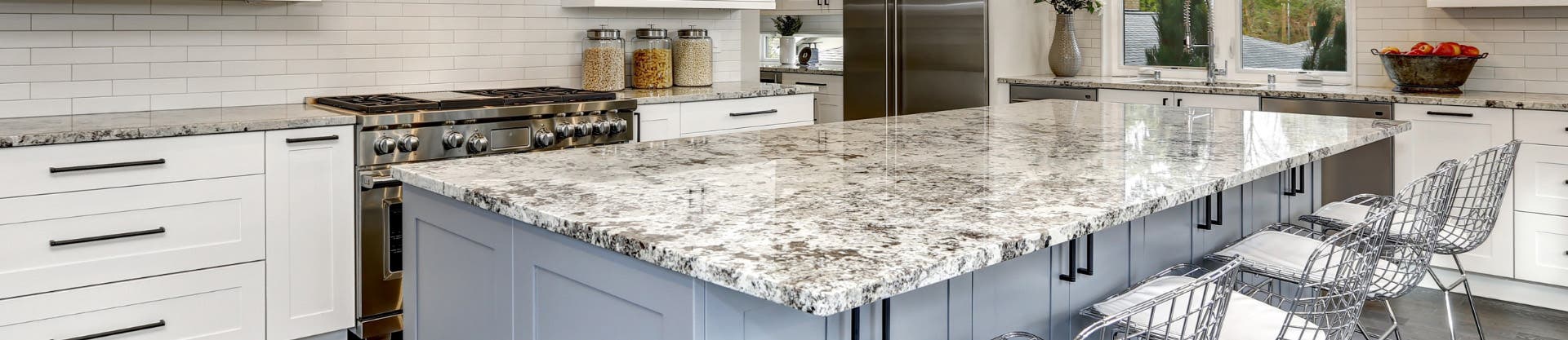 White and gray shaker kitchen cabinets with patterned granite countertops