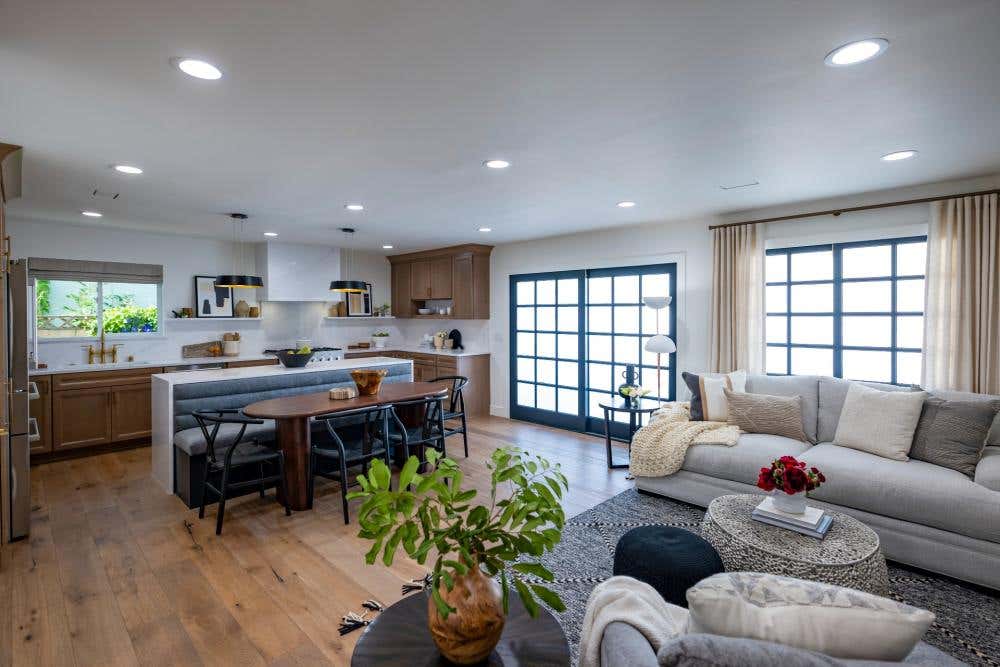 Light wood cabinets with indigo island and white stone countertops and hood