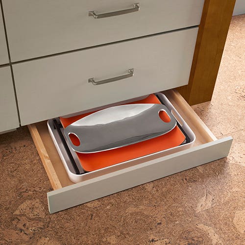 Toekick pull-out storage in gray slab door kitchen cabinets