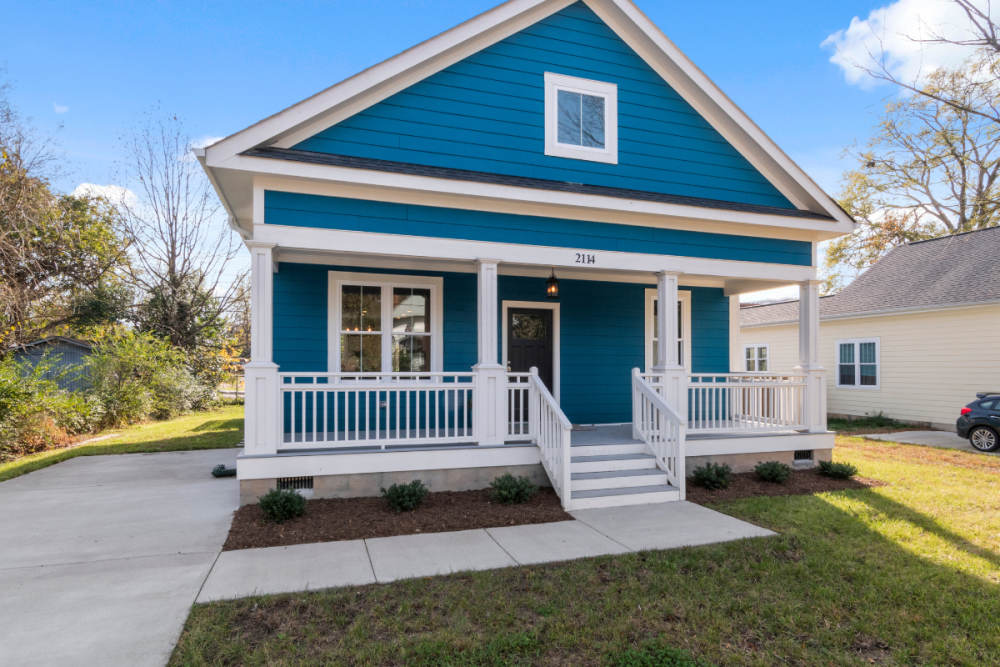 Turquoise bungalow house with white trim and rails