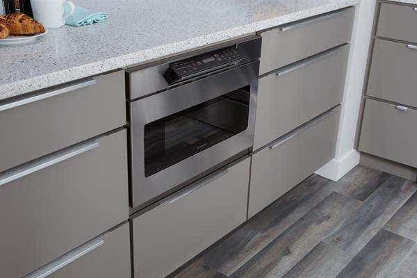 Stainless steel undercounter built-in microwave drawer with gray slab kitchen cabinets Stainless steel undercounter built-in microwave drawer with gray slab kitchen cabinets
