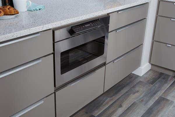 Stainless steel undercounter built-in microwave drawer with gray slab kitchen cabinets