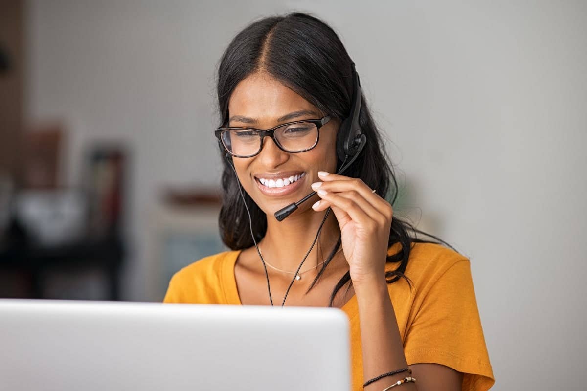 Smiling woman with a computer on her headset talking with a customer.