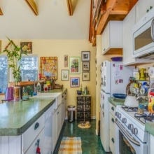 Kevin's Emeryville, California remodel of 1950s bungalow includes an open galley kitchen with white cabinets that he describes as 