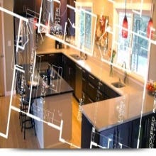 Espresso shaker kitchen cabinets with expansive brown granite countertops and red pendant lights with a floor plan overlay on photo