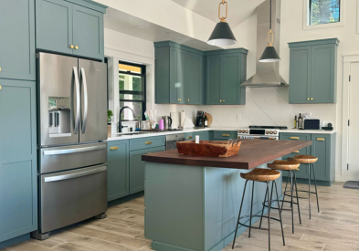 Light blue large shaker kitchen design with an island, gold hardware and dark butcher block countertops