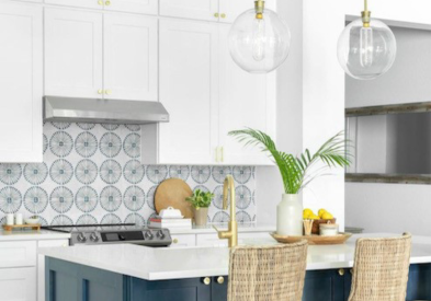 Stacked RTA white shaker kitchen cabinets with gold cabinet hardware and a navy blue island with white quartz countertops 