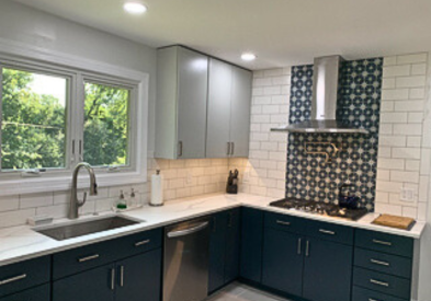 Light gray slab door wall cabinets and navy blue slab door base cabinets with white quartz countertops