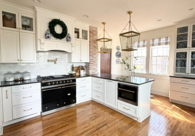 Grand white shaker kitchen design with matching wood hood and stacked glass cabinets