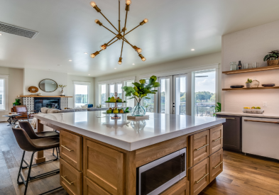 Light oak shaker kitchen cabinets with island and decorative modern chandelier