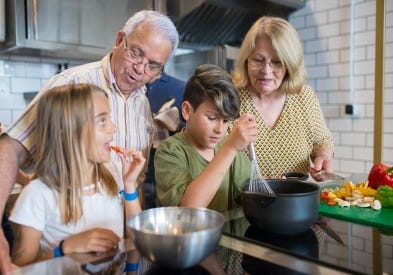 Grandparents cooking in kitchen with grand kids