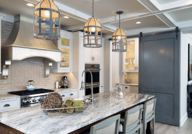 Fantasy Brown granite countertops in a large high-end kitchen with a big island, wood hood and white inset shaker cabinets