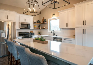 Light gray and white L-shaped kitchen design with a shaker door style and gray island cabinets