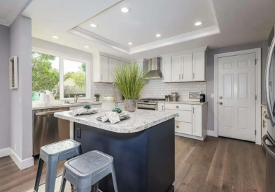 White L-shaped shaker kitchen design with black center island and white quartz countertops