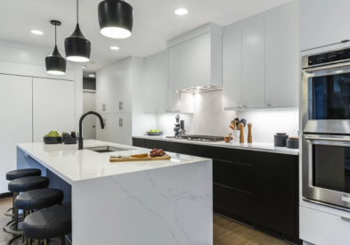 White slab door kitchen cabinets with a white quartz waterfall countertop.