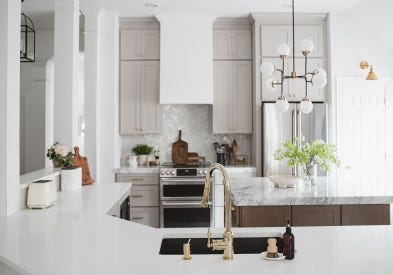 Shaker kitchen cabinets in light gray and medium-brown stained island