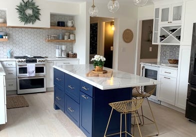 Farmhouse style white shaker kitchen cabinets and blue island with gold hardware