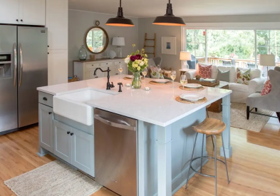 Light gray inset shaker kitchen design in Farmhouse style with large island and black pendants above