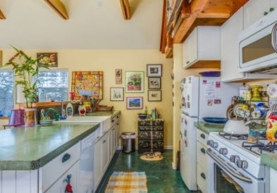 Kevin's Emeryville, California remodel of 1950s bungalow includes an open galley kitchen with white cabinets that he describes as 