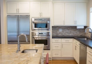 Photo gallery of remodeled kitchen features CliqStudios Shaker Painted White cabinets with apron-front farmhouse sink and furniture-styled island