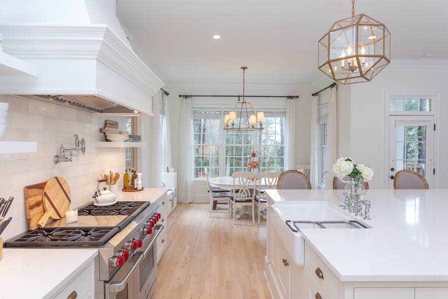 White Inset Door Shaker Cabinet Drawers with stainless steel Wolf range and a farmhouse sink.