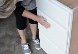 Woman looking at a CliqStudios cabinet drawer fronts. Woman looking at a CliqStudios cabinet drawer fronts.