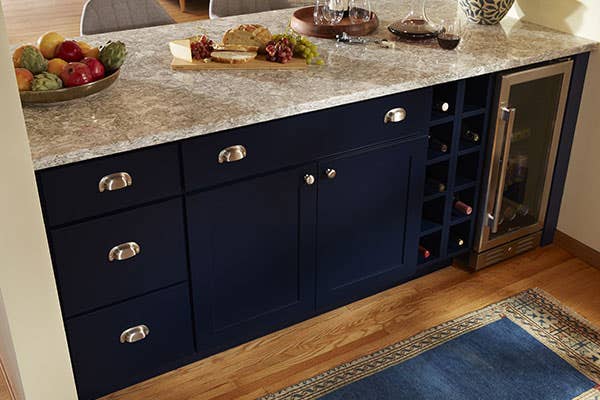 Navy shaker buffet base cabinets with brushed nickel drawer pulls and knobs with gray quartz countertops