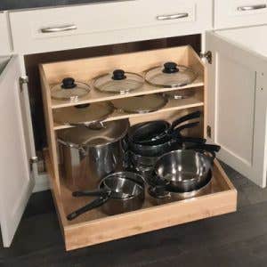 Pots and pans pull-out organizer inside a white shaker base cabinet