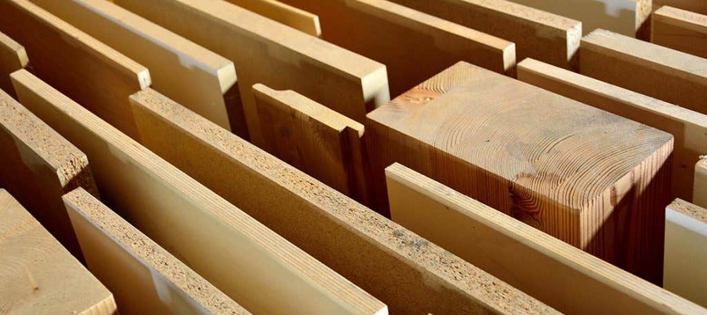 stack of kitchen cabinet materials including hardwood, plywood, medium-density fiberboard (MDF), and particleboard