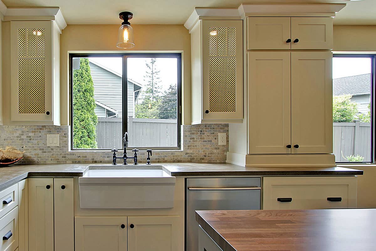 Traditional-style cream kitchen cabinets with black cabinet knobs and pulls