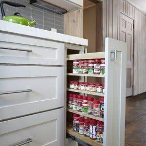 Light gray shaker base cabinets with a pull-out spice cabinet