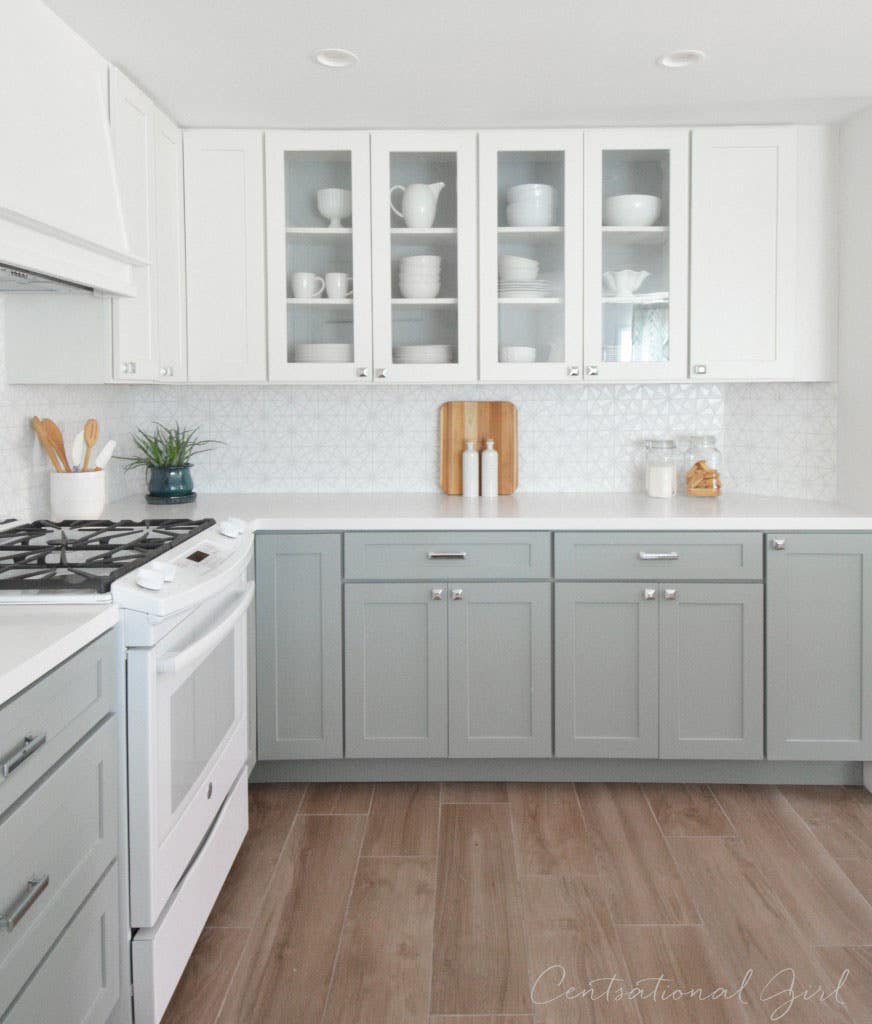 White and light gray kitchen storage cabinets with a white wood hood and range