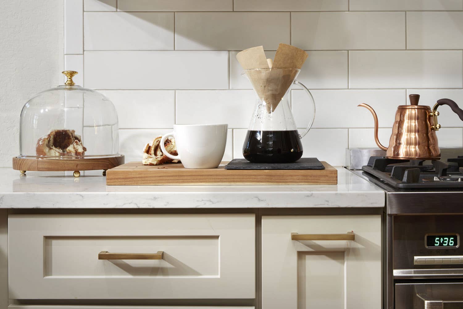 Marble kitchen countertop with cutting board, coffee, and kitchen storage below