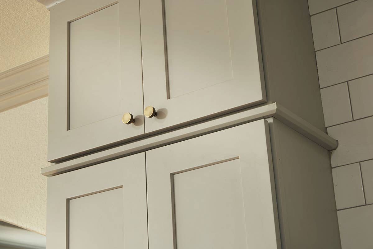 aged brass knobs on light gray shaker cabinets