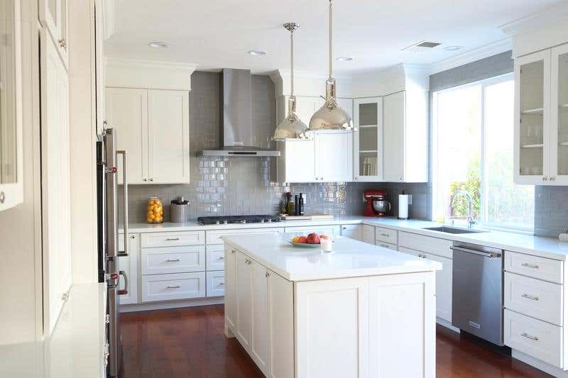 shaker style cabinets in white with pendant lights and a kitchen island