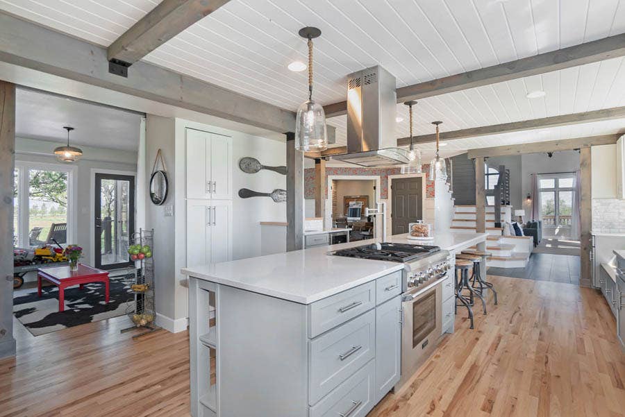 wood floors contrast with gray and white cabinetry in farmhouse kitchen.