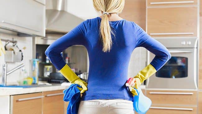 Woman surveying the kitchen while cleaning Woman surveying the kitchen while cleaning