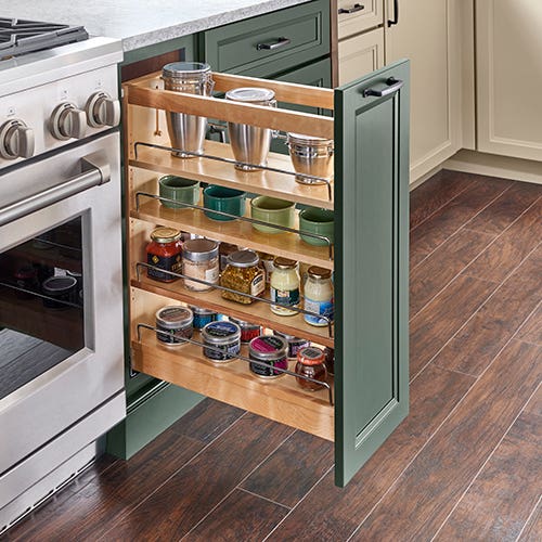 Pull-out spice cabinet with multiple adjustable shelves next to range appliance with painted green cabinet door Pull-out spice cabinet with multiple adjustable shelves next to range appliance with painted green cabinet door