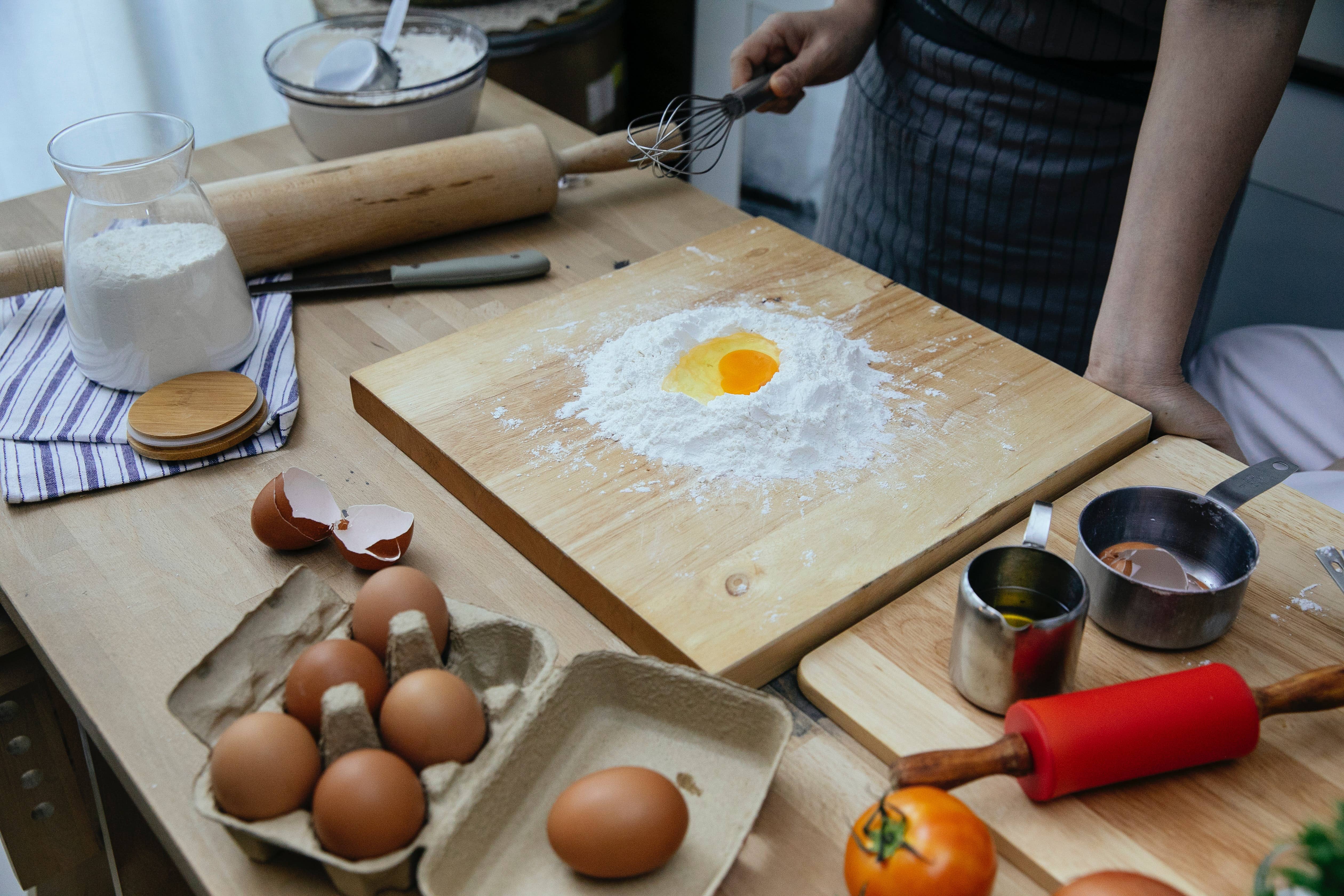 Person making pasta on wood butcher block kitchen island countertop