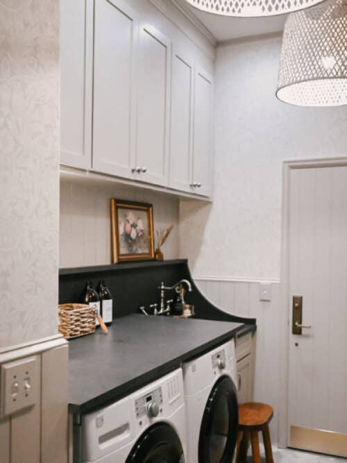 Berkeley Chai Latte laundry room cabinets Laundry room wall with white frontloading washer and dryer with black quartz countertops and beige cabinets above