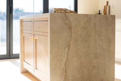 Brentwood Oak Cappuccino kitchen island cabinets Light oak kitchen island with gold hardware and quartzite waterfall countertop