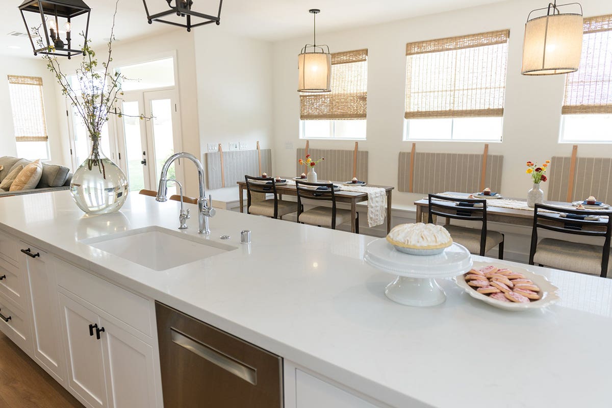 Long white inset shaker cabinet island with all white quartz countertops