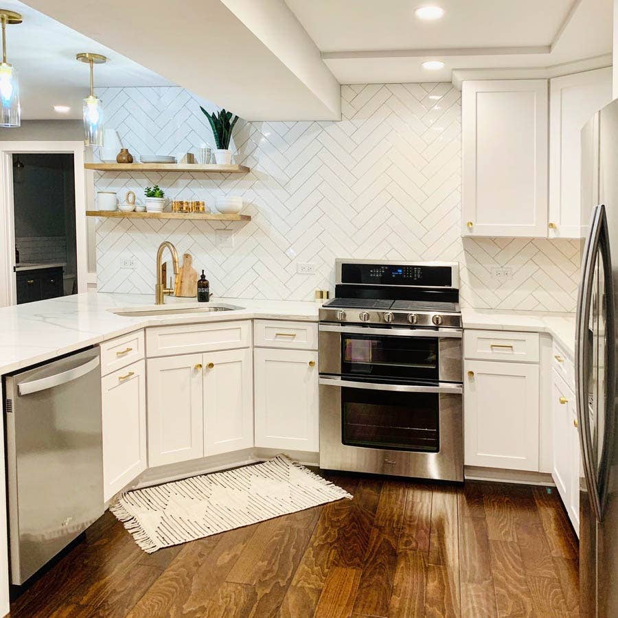 Shaker Cabinets in White, a herringbone backsplash, and pendant lighting. Shaker Cabinets in White, a herringbone backsplash, and pendant lighting.