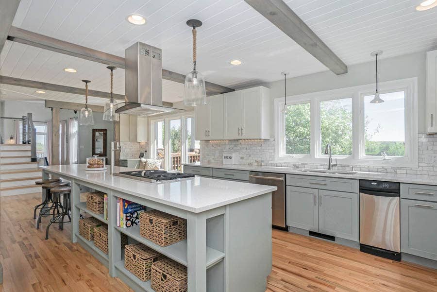 Open gray kitchen island using voided doors for storage space.