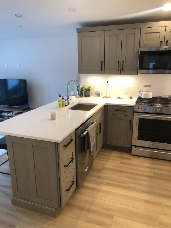Light gray shaker kitchen design with peninsula and black hardware Light gray shaker kitchen design with peninsula and black hardware