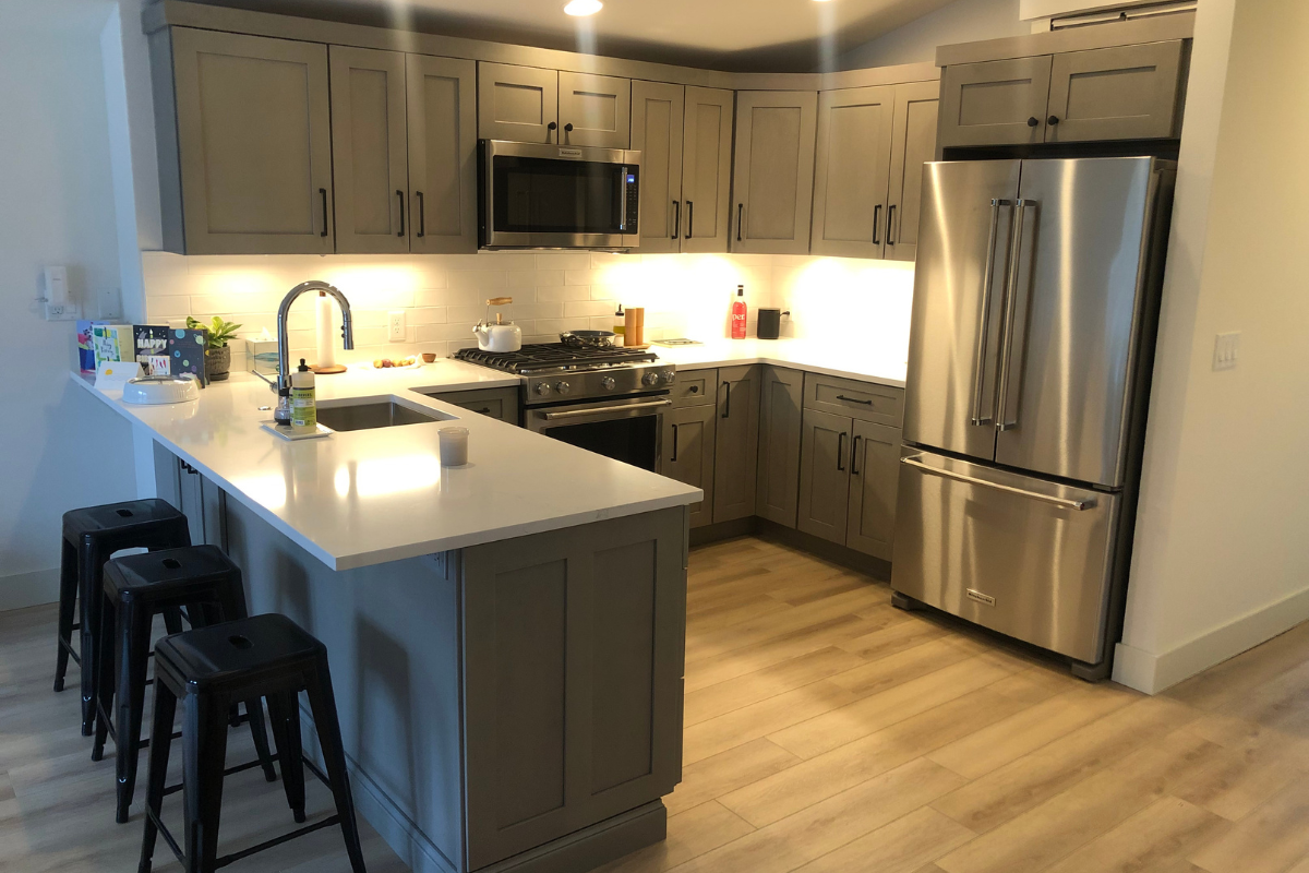 Light gray shaker kitchen design with peninsula and black hardware Light gray shaker kitchen design with peninsula and black hardware