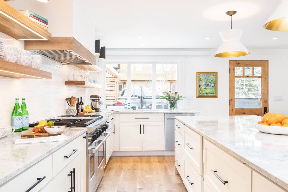 Painted White shaker kitchen base cabinets and island with white hood and natural wood floating shelves and large pendants Painted White shaker kitchen base cabinets and island with white hood and natural wood floating shelves and large pendants