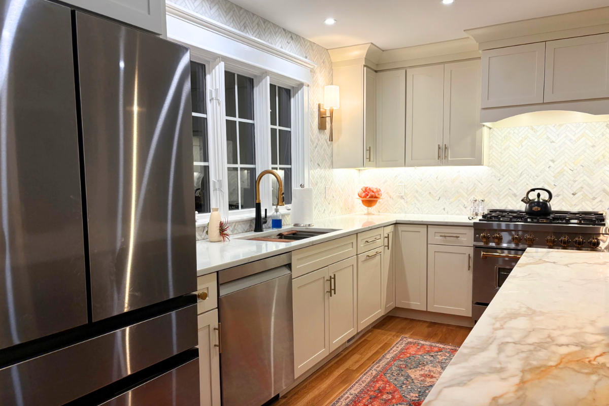 Large L-shaped white shaker kitchen design with a long navy island and white stone countertops