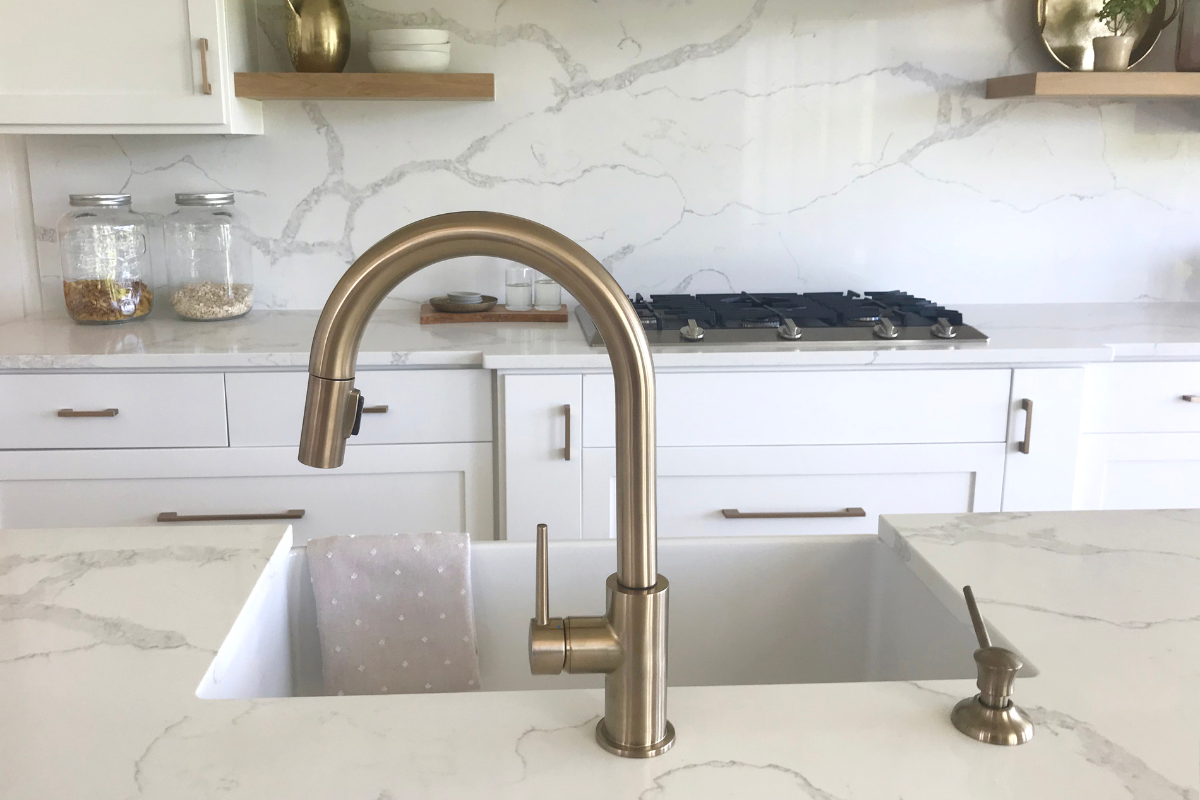 White shaker kitchen cabinets with gold goose neck faucet, cabinet hardware, and decor White shaker kitchen cabinets with gold goose neck faucet, cabinet hardware, and decor